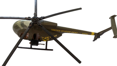 A scale model of a United States Army Bell 206 helicopter in olive drab green and black, featuring yellow printed text and insignia, photographed from an overhead angle on a white background.