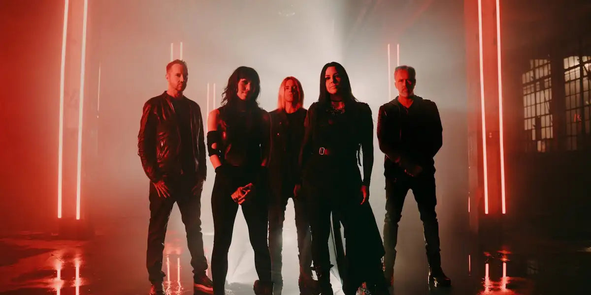 Five people standing in a row with red neon lights in a dark setting. The band Evanesence.
