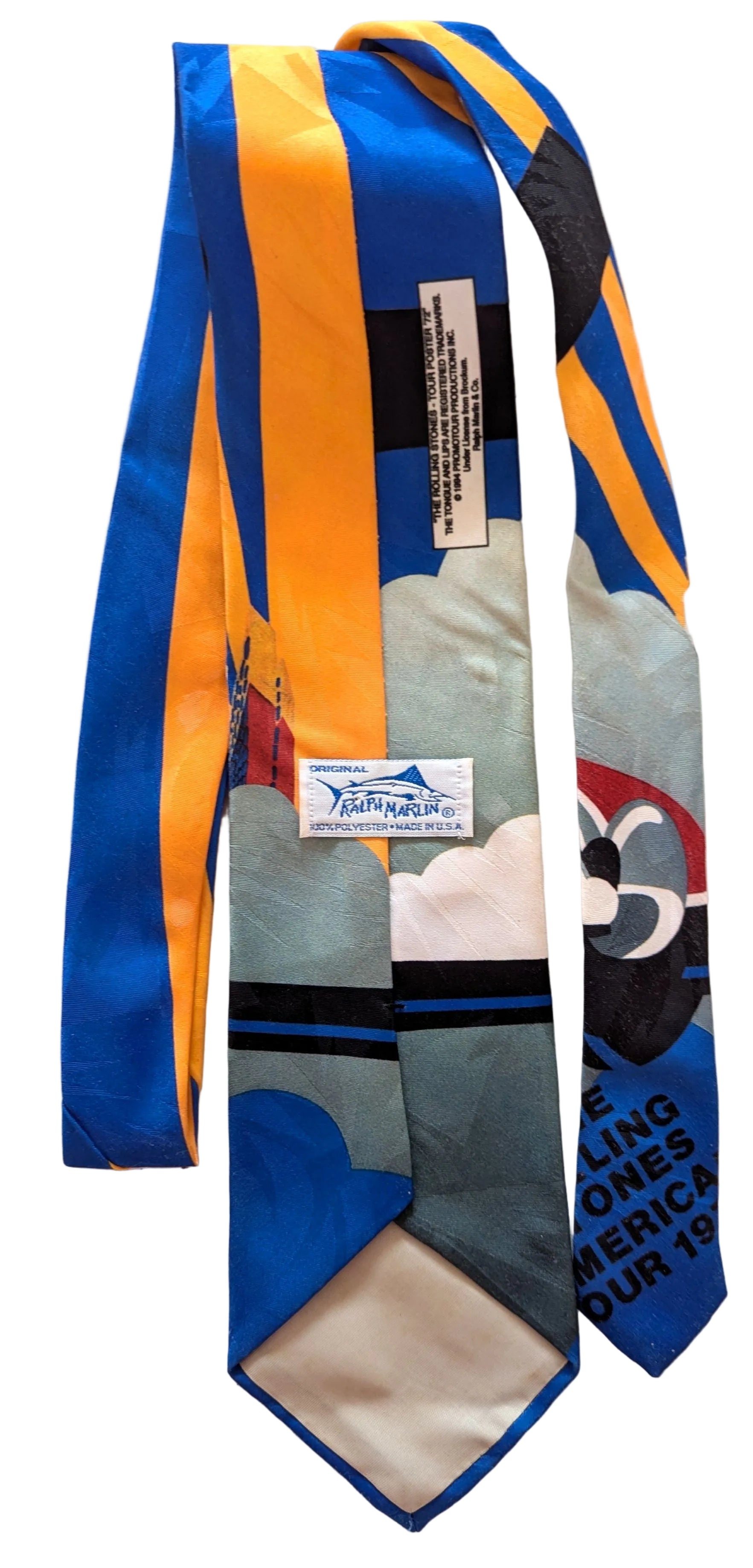 A vintage necktie featuring a colorful abstract design with blue, yellow, gray, black, and white sections, along with printed text and a small brand label.