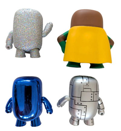 Four small stylized character figures arranged on a light neutral surface, each shown from a different angle: one silver glitter figure, one yellow-and-green figure seen from the back, one metallic blue figure, and one silver robot figure.