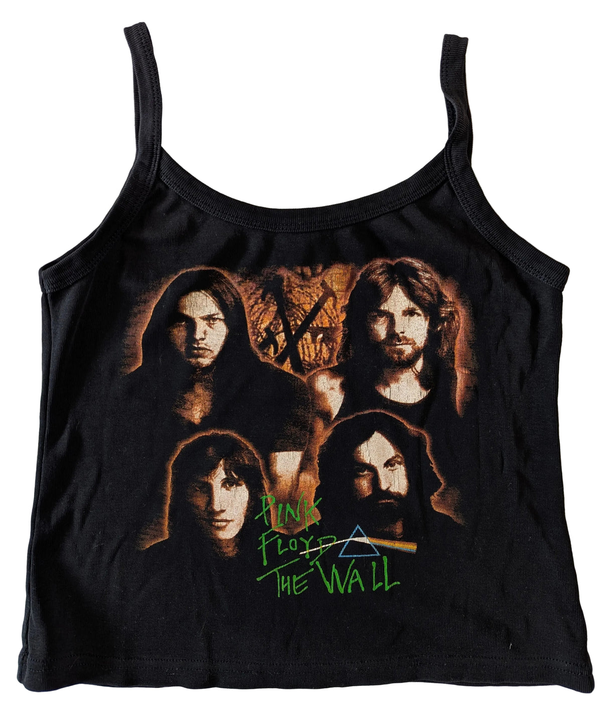 A black sleeveless tank top featuring a front graphic print of the band Pink Floyd's 'The Wall' album artwork, laid flat on a white wooden background.