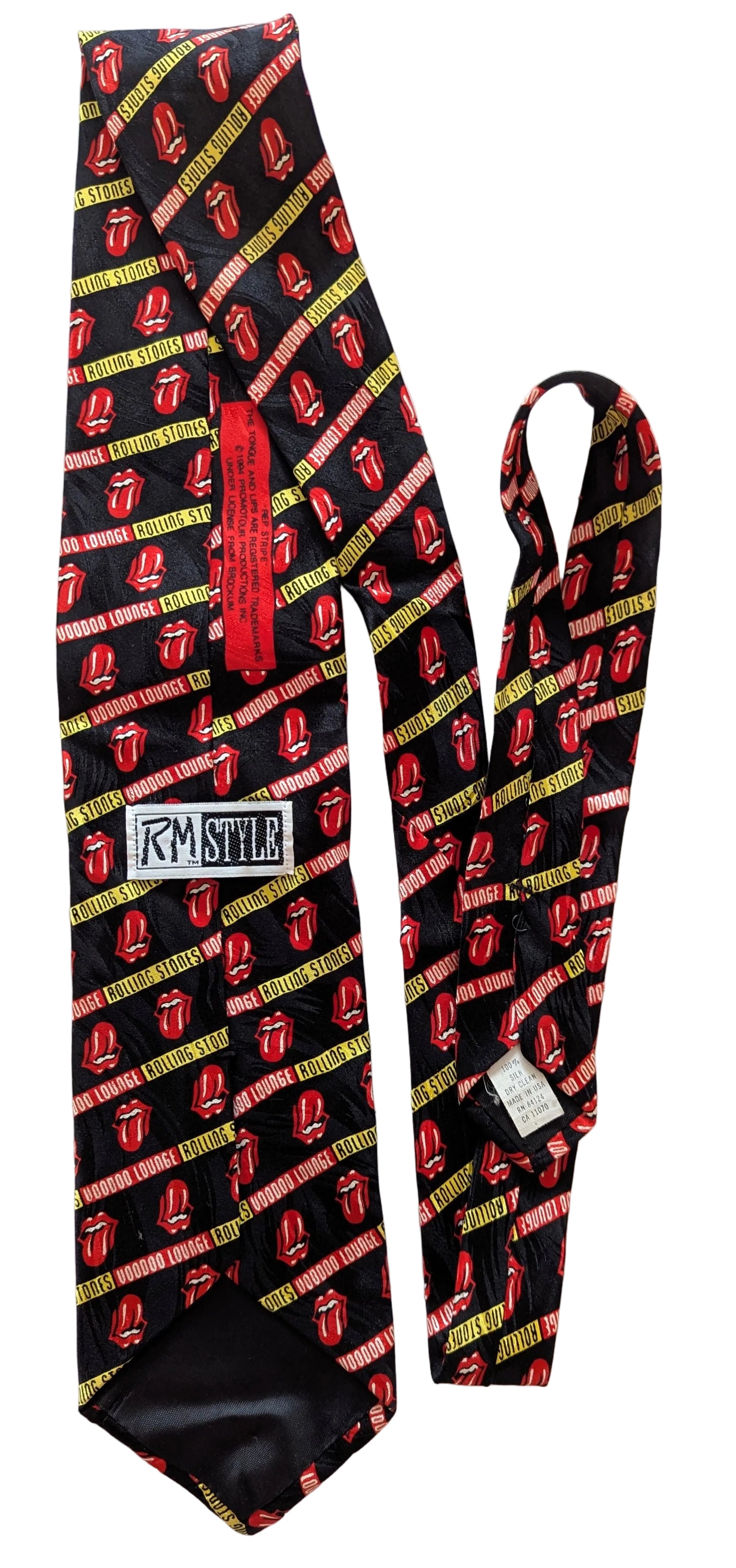 A black necktie with a repeating red and yellow tongue pattern, featuring a red neck strap and a white 'RM STYLE' brand patch on the back.