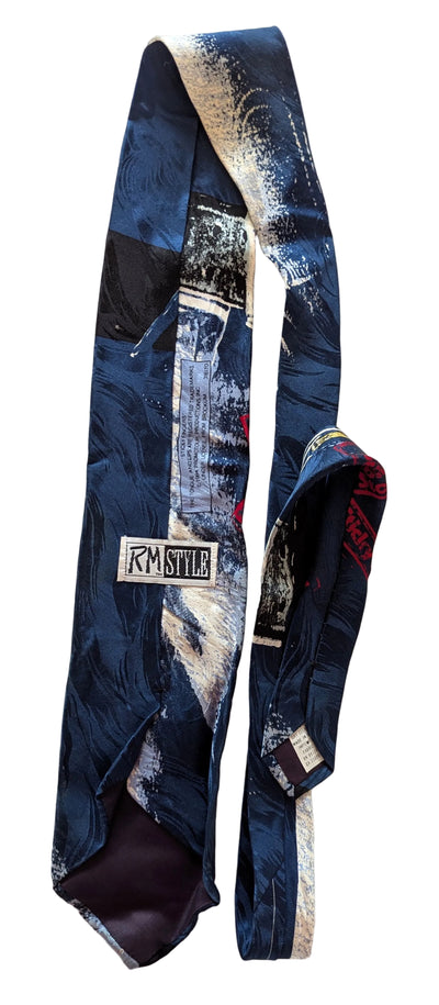 A slim necktie with an abstract painterly pattern in navy blue, black, white, and gray, featuring a visible 'RM Style' brand label on the back.